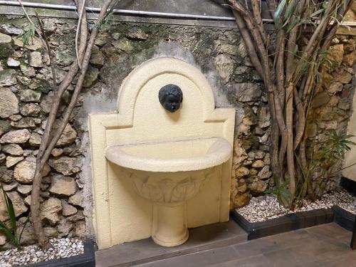 a statue of a sink in a stone wall at Hôtel Vendôme in Aix-en-Provence