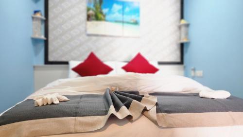 a bedroom with a bed with red pillows at Isle inn {Fuvahmulah) in Fuvahmulah