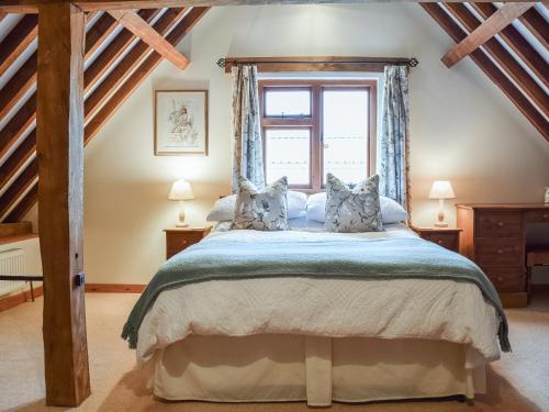um quarto com uma cama grande e uma janela em The Old Stable - Meadowbrook Farm em Thame