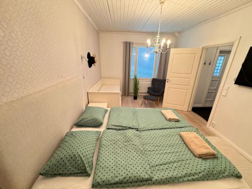 a bedroom with two green beds in a room at Spacious apartment in the city center in Vaasa