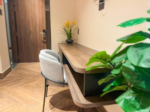 a desk with a chair and a plant at KHÁCH SẠN THƯ LÊ LUXURY in Cao Lãnh