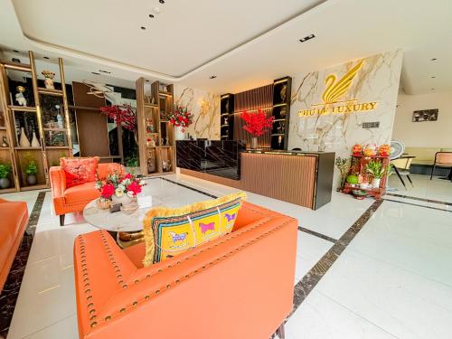 an empty lobby with orange chairs and a table at KHÁCH SẠN THƯ LÊ LUXURY in Cao Lãnh