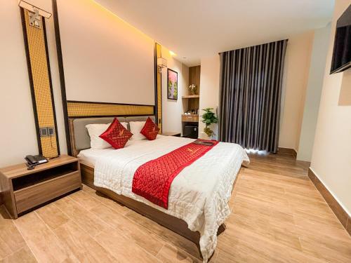 a bedroom with a large bed with red pillows at KHÁCH SẠN THƯ LÊ LUXURY in Cao Lãnh