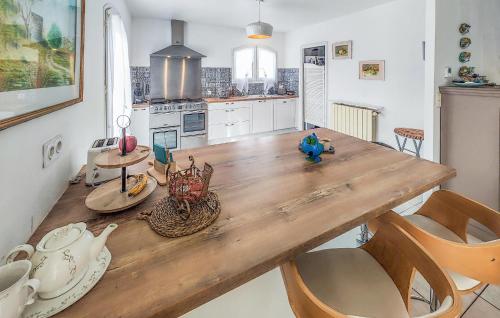 a large kitchen with a wooden table and chairs at Stunning Home In Caux in Caux