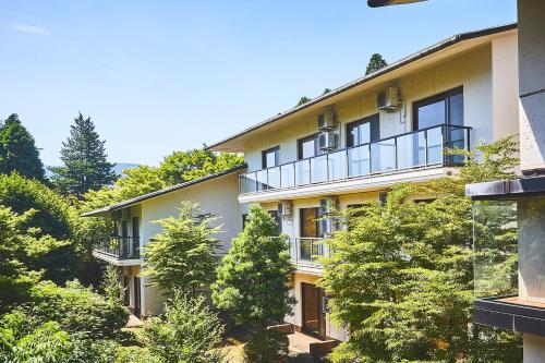 an apartment building with trees in front of it at Shiki Resort Gora Saika in Hakone