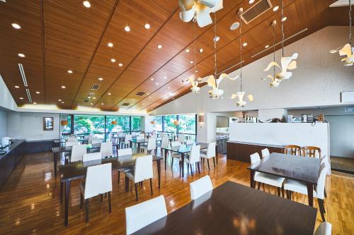 a dining room with tables and white chairs at Shiki Resort Gora Saika in Hakone