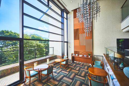a room with tables and chairs and a large window at Shiki Resort Gora Saika in Hakone