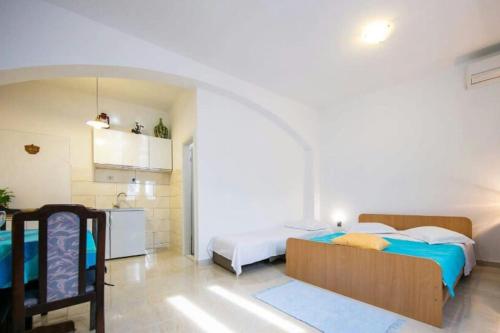 1 dormitorio con 2 camas y cocina. en Seafront apartment Jurkovica en Komiža