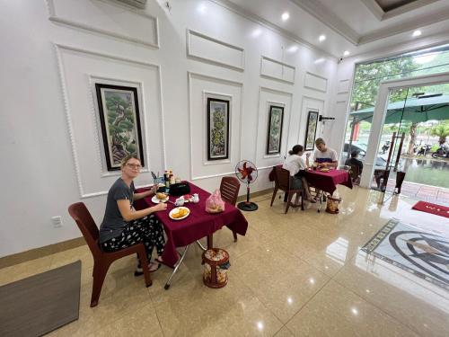 a woman sitting at a table in a restaurant at Bao Phuc Hotel in Cat Ba