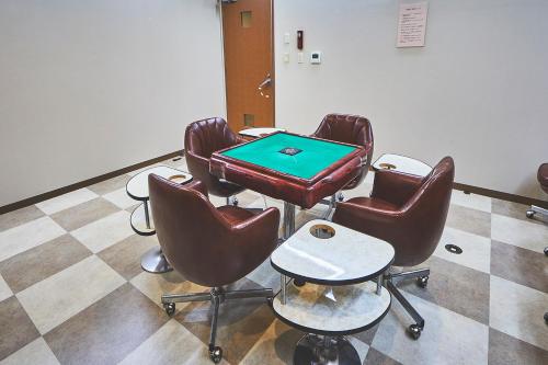 a room with a ping pong table and leather chairs at Shiki Resort Hakone Style in Hakone