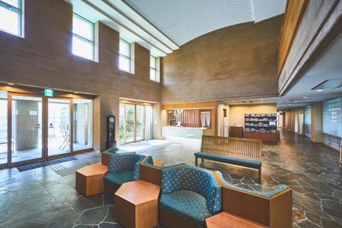 a lobby with couches and tables in a building at Shiki Resort Hakone Style in Hakone