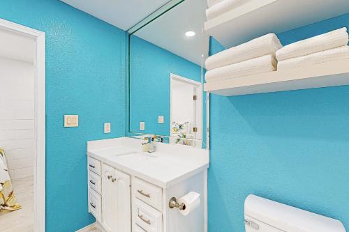 baño con lavabo blanco y pared azul en Harbor Bay Home and Studio, en Port Isabel