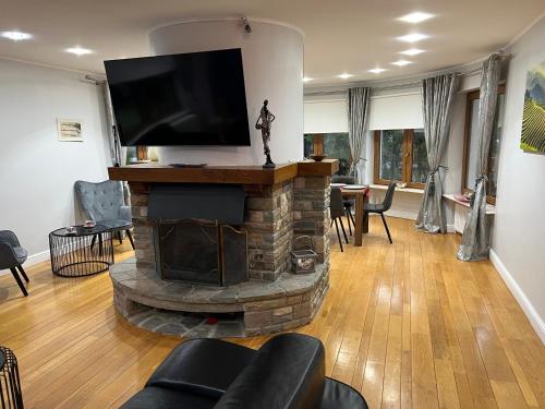 a living room with a fireplace with a flat screen tv at Le Joyau de Balmoral in Sart-lez-Spa
