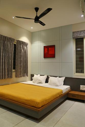a bedroom with a bed with a ceiling fan at Sumadhu Homes -Family Homestay in Kolhapur