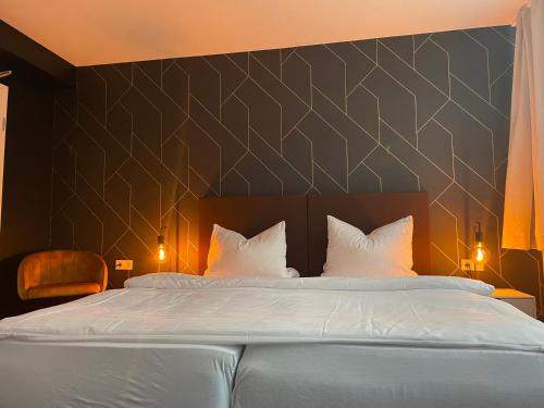 a bedroom with a large bed with white pillows at MOTELO Bielefeld - Smart HOTEL in Bielefeld