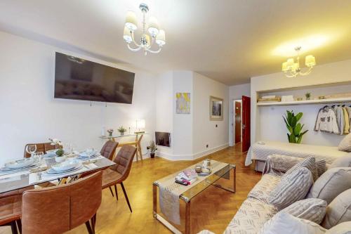 ein Wohnzimmer mit einem Sofa und einem Tisch in der Unterkunft Park Lane Apartments Mayfair Collection in London