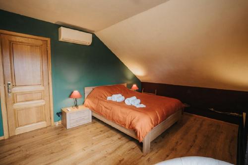 a bedroom with a bed with two towels on it at Le refuge de Kila in Waimes