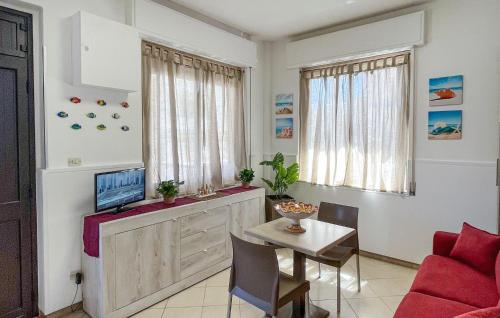 a living room with a red couch and a table at Nice Apartment In Marzamemi in Marzamemi