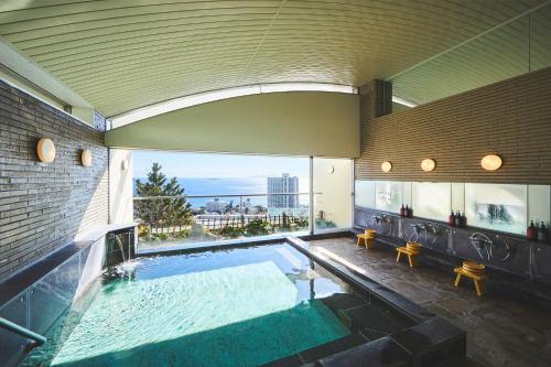 uma grande piscina interior num edifício em Shiki Resort Atami Boyokan em Atami