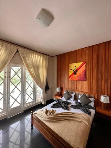 1 dormitorio con cama grande y ventana grande en Maples Holiday Resort, en Nuwara Eliya