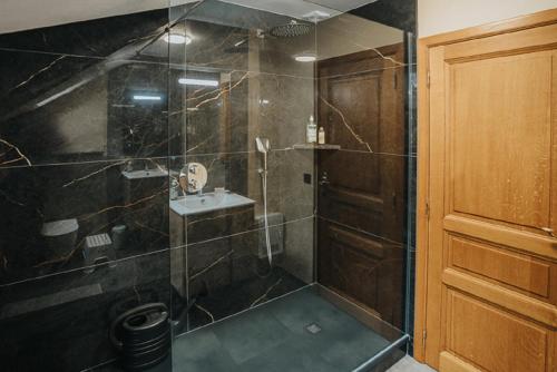 a bathroom with a shower with a sink at Le refuge de Kila in Waimes