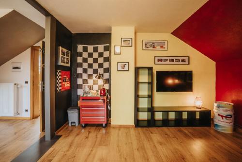 a living room with a red and yellow wall at Le refuge de Kila in Waimes