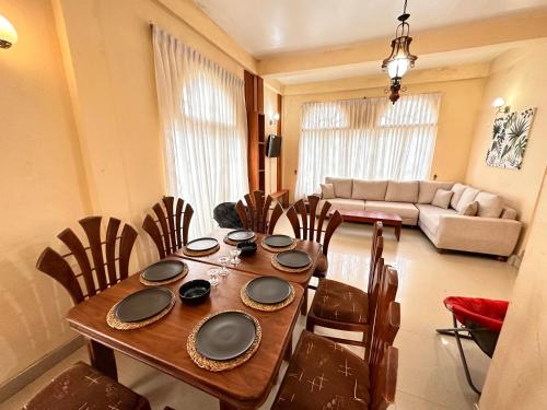 comedor con mesa de madera y sillas en Maples Holiday Resort, en Nuwara Eliya