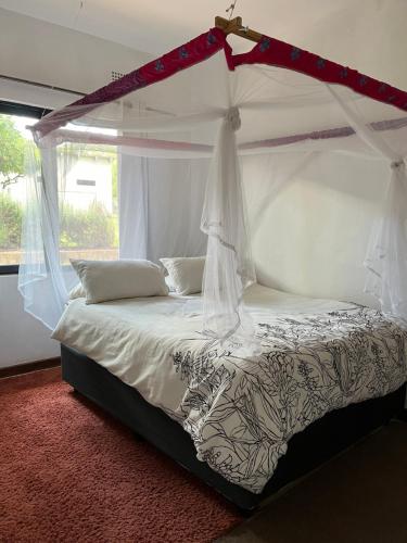 un letto a baldacchino in una stanza di Golden Bean Grove a Lusaka