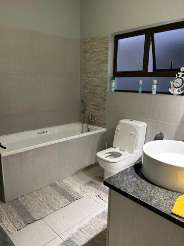 La salle de bains est pourvue d'une baignoire, de toilettes et d'un lavabo. dans l'établissement SOMS Langstrand Self Catering, à Langstrand