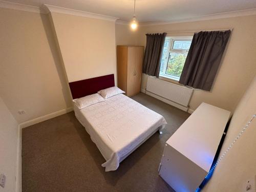 a small bedroom with a bed and a window at House Dollis Hill in London