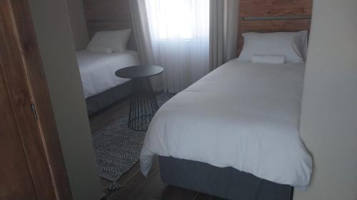 Schlafzimmer mit einem Bett, einem Tisch und einem Fenster in der Unterkunft Seqonoka Villa Accommodation & Events Park in Berea Hills