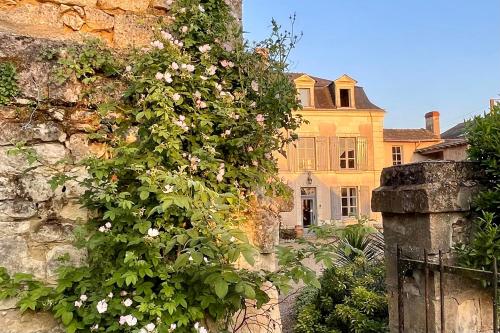 The Old Winery, Loire في Le Puy-Notre-Dame: مبنى عليه باقة ورد على الحائط