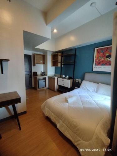 a bedroom with a large bed and a kitchen at I Suites Malate in Manila