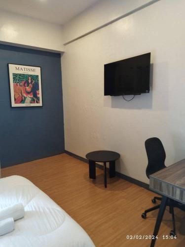 a room with a bed and a flat screen tv on a wall at I Suites Malate in Manila