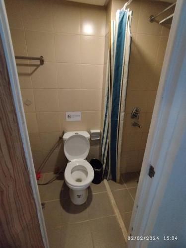 a small bathroom with a toilet and a shower at I Suites Malate in Manila