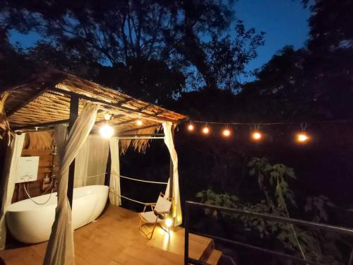 a bath tub sitting on a deck at night at The River whisper in Ban Ton Kham