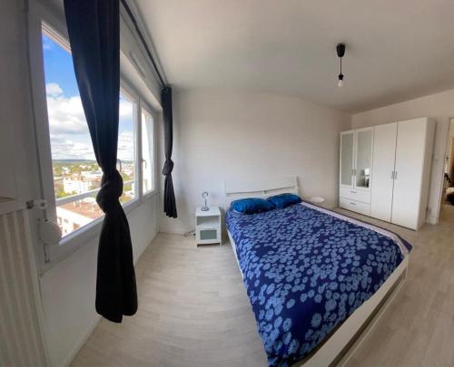 Un dormitorio con una cama y una ventana grande en F2 65m2 parking privé avec une belle vue, en Metz