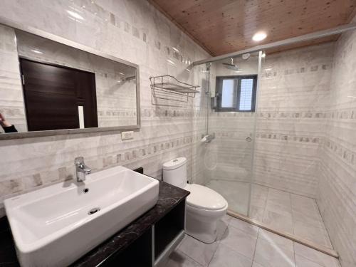 a white bathroom with a sink and a toilet at Cai Jyu B&B in Magong