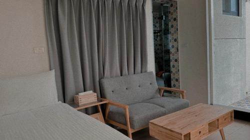 a bedroom with a bed and a chair and a table at 飛行船電梯民宿 in Taitung City