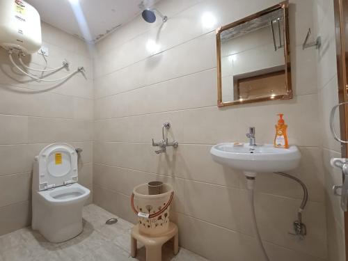 y baño con lavabo, aseo y espejo. en Luxury Homestay en Varanasi