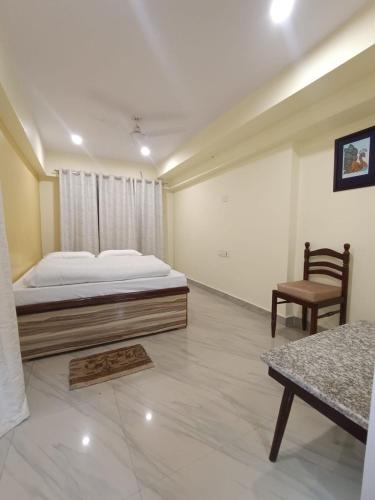 een slaapkamer met een bed en een stoel erin bij Luxury Homestay in Varanasi