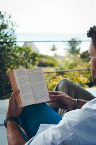 a man sitting down reading a book at Duna Sonambula in Praia do Tofo