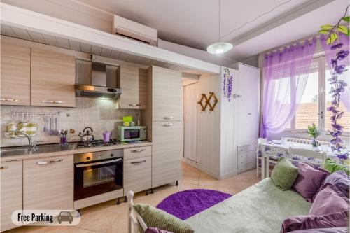 een keuken en een woonkamer met een bank en een tafel bij 15 min da Malpensa - Free Parking & Self Check-In in Cassano Magnago