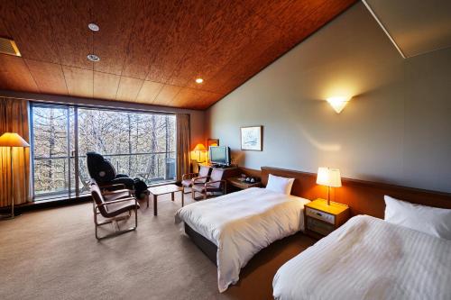 een hotelkamer met 2 bedden en een raam bij Shiki Resort Ventvert Karuizawa in Karuizawa