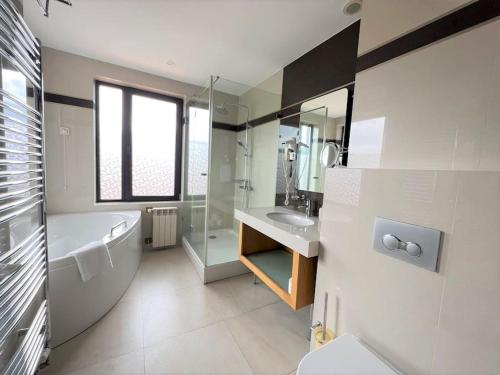een badkamer met een bad, een wastafel en een toilet bij Villa in Ruskovets Resort in Dobrinishte