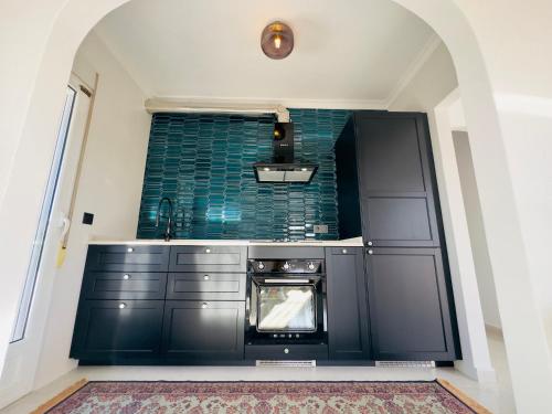 cocina con armarios negros y microondas en 2 bedroom villa with private swimming pool, en San Juan de los Terreros