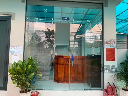 una puerta de entrada de cristal a un edificio con puerta en Nhà nghỉ Quốc Khánh, en Dồng Xoài