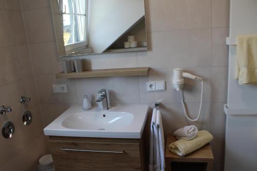 a bathroom with a sink and a mirror at Ferienweingut Hansjosten in Longuich