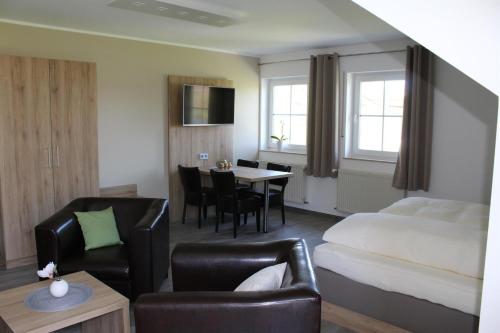 um quarto de hotel com uma cama, uma mesa e cadeiras em Ferienweingut Hansjosten em Longuich