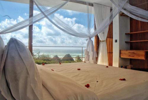 um quarto com uma cama e vista para o oceano em Duna Sonambula em Praia do Tofo